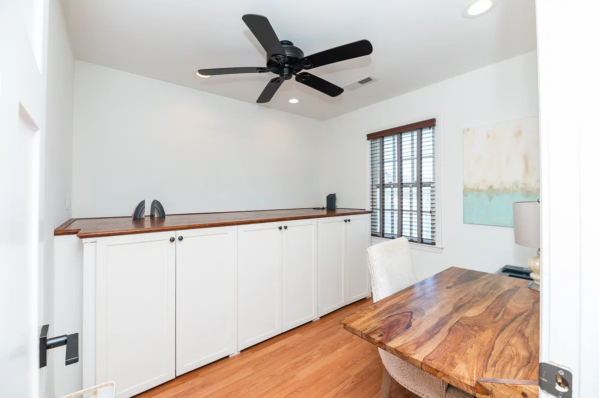 An interior shot highlighting a serene workspace with a wooden countertop desk, window for natural light, and inspiring artwork. The space is quiet and tailored for focused work or creative inspiration, reflecting the balance between productivity and relaxation.
